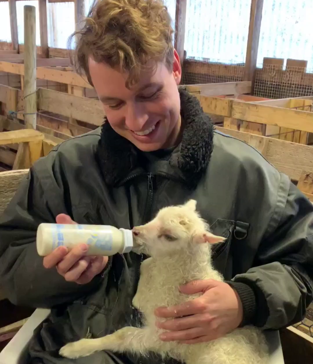 Justin Strong feeding a baby goat.